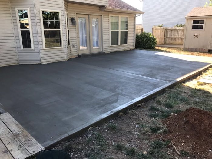 New broom-finish concrete patio behind a home