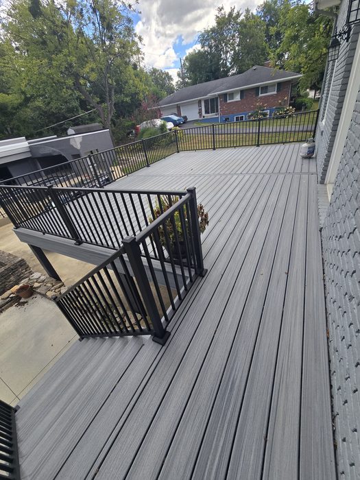Composite deck surface and stair landing with black railings