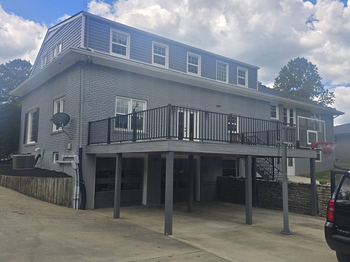 Elevated composite deck across the back of a painted brick home