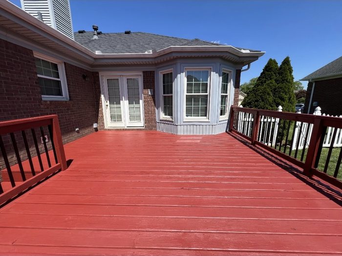 Large wood deck and railings finished in a red solid stain