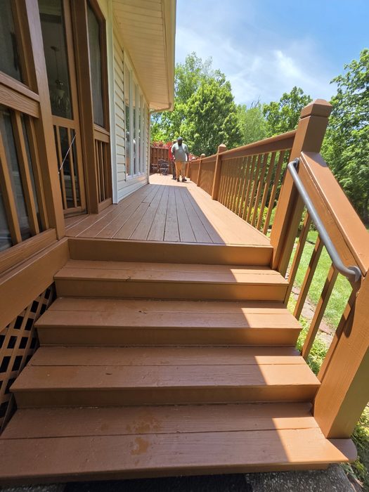 Wraparound wood deck and stairs finished in a cedar-tone stain